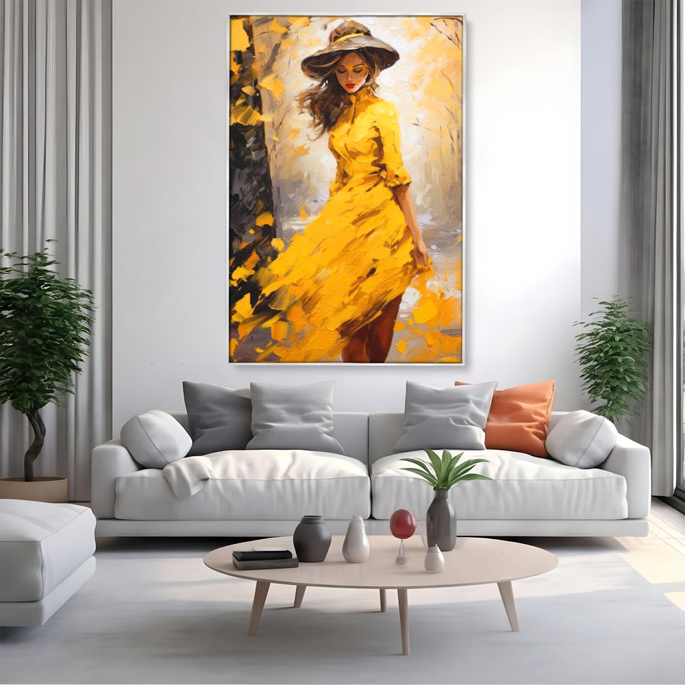 Tablou canvas cu tablou canvas cu femeie in galben, in rama de aluminiu argintiu, pe perete intr-un living